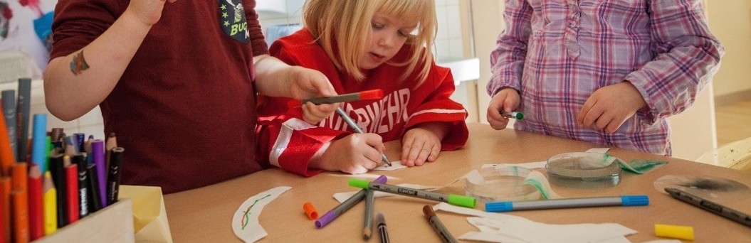 Kinder experimentieren mit Wasser und Farbe auf Filtertüten